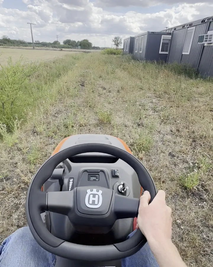 Fűnyíró traktor kormánya, kaszálás közben egy telephelyen