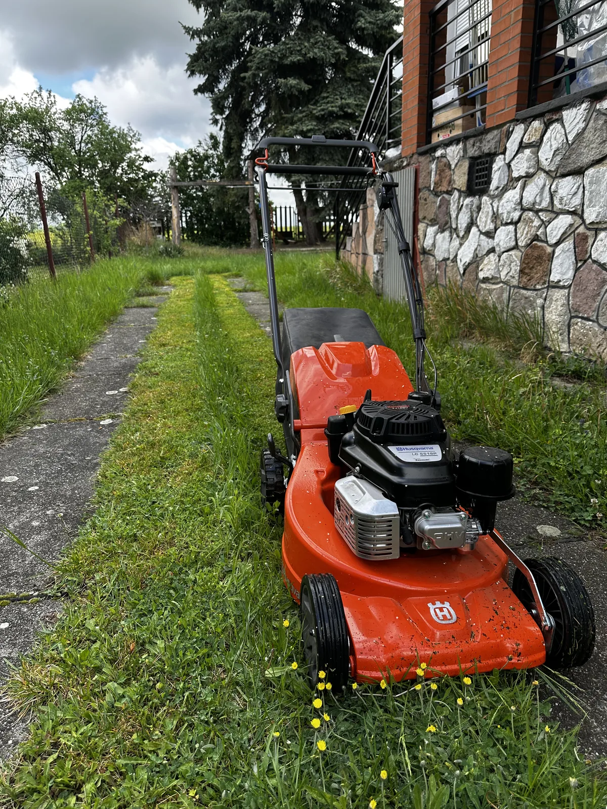 tolós fűnyírás közben – Husqvarna gép közelről, rendezett kertkörnyezetben | Tiszta Zóna