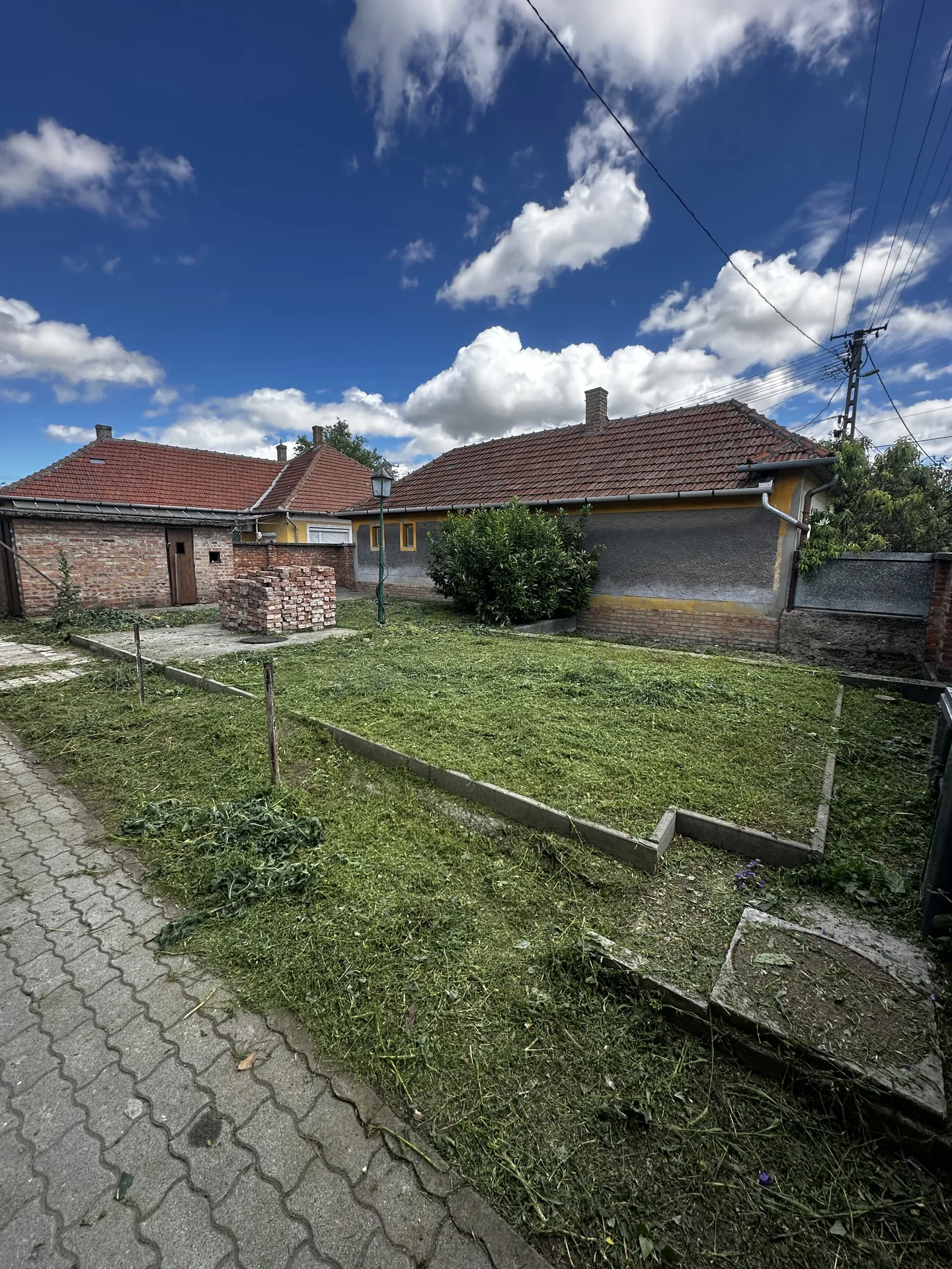Lenyírt udvar házzal – fűnyírás után | Tiszta Zóna
